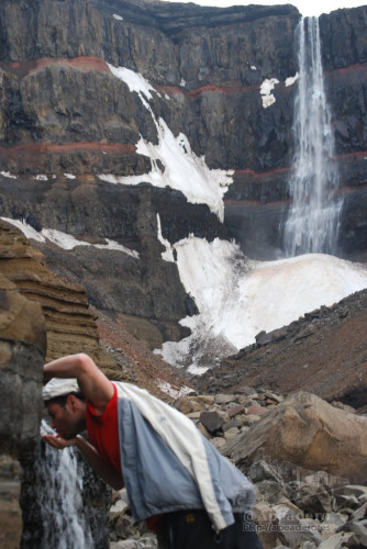 Jorge bebiendo agua pura frente a la gran catarata de Hengifoss tras un gran trekking.