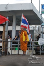 Todo un emblema de Tailandia, un monje apoyado en una bandera, solo le falta la foto del rey
